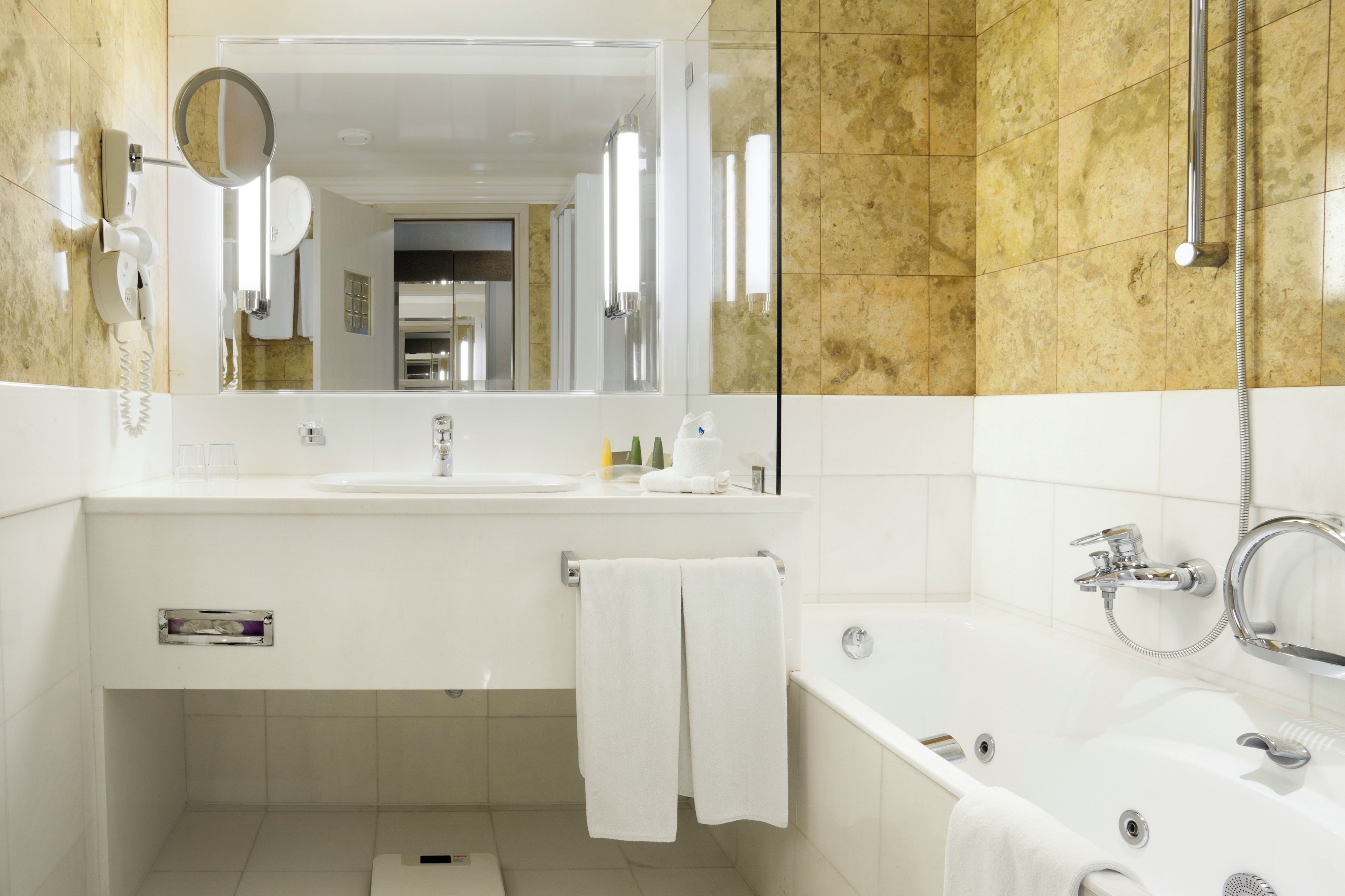A modern bathroom with a large mirror, a sink, a bathtub, and a shower.