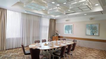 A conference room with a large table, chairs, and a ceiling with recessed lighting.