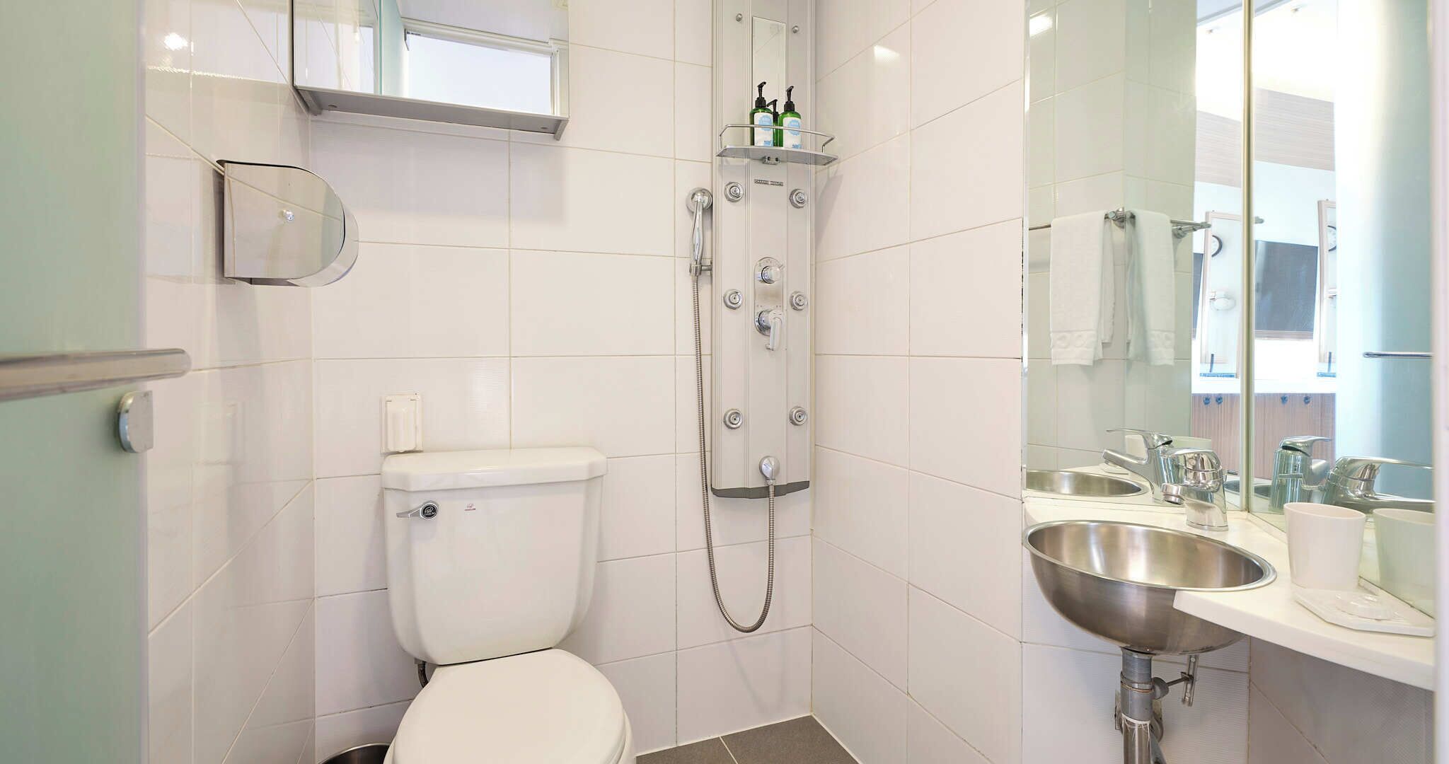 A modern bathroom with a toilet, shower, and sink.