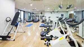 A gym with cardio machines, weight benches, and exercise mats. - Uljiro Co-Op Residence (Seoul)