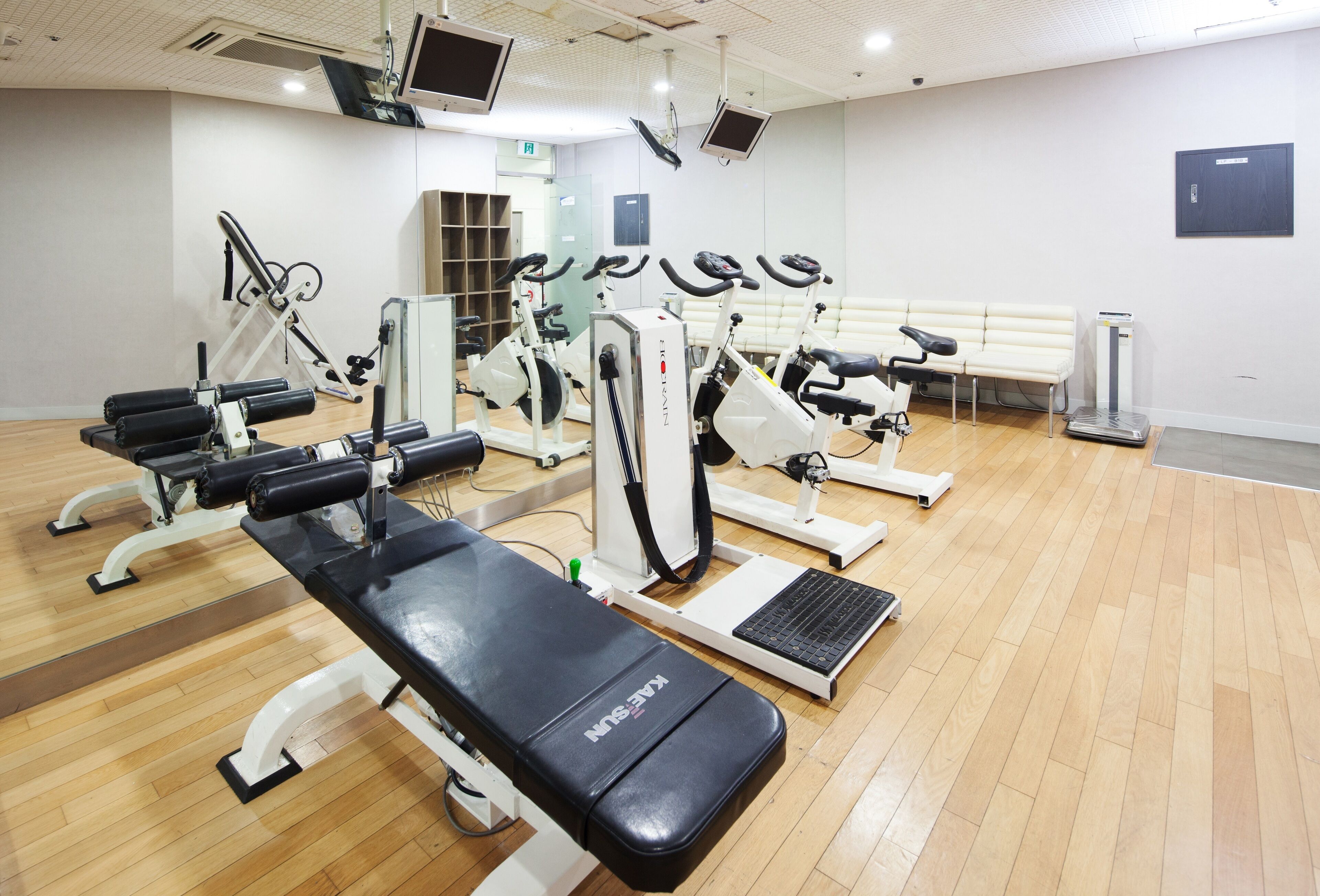 A gym with various exercise equipment, including treadmills, stationary bikes, and weight machines.