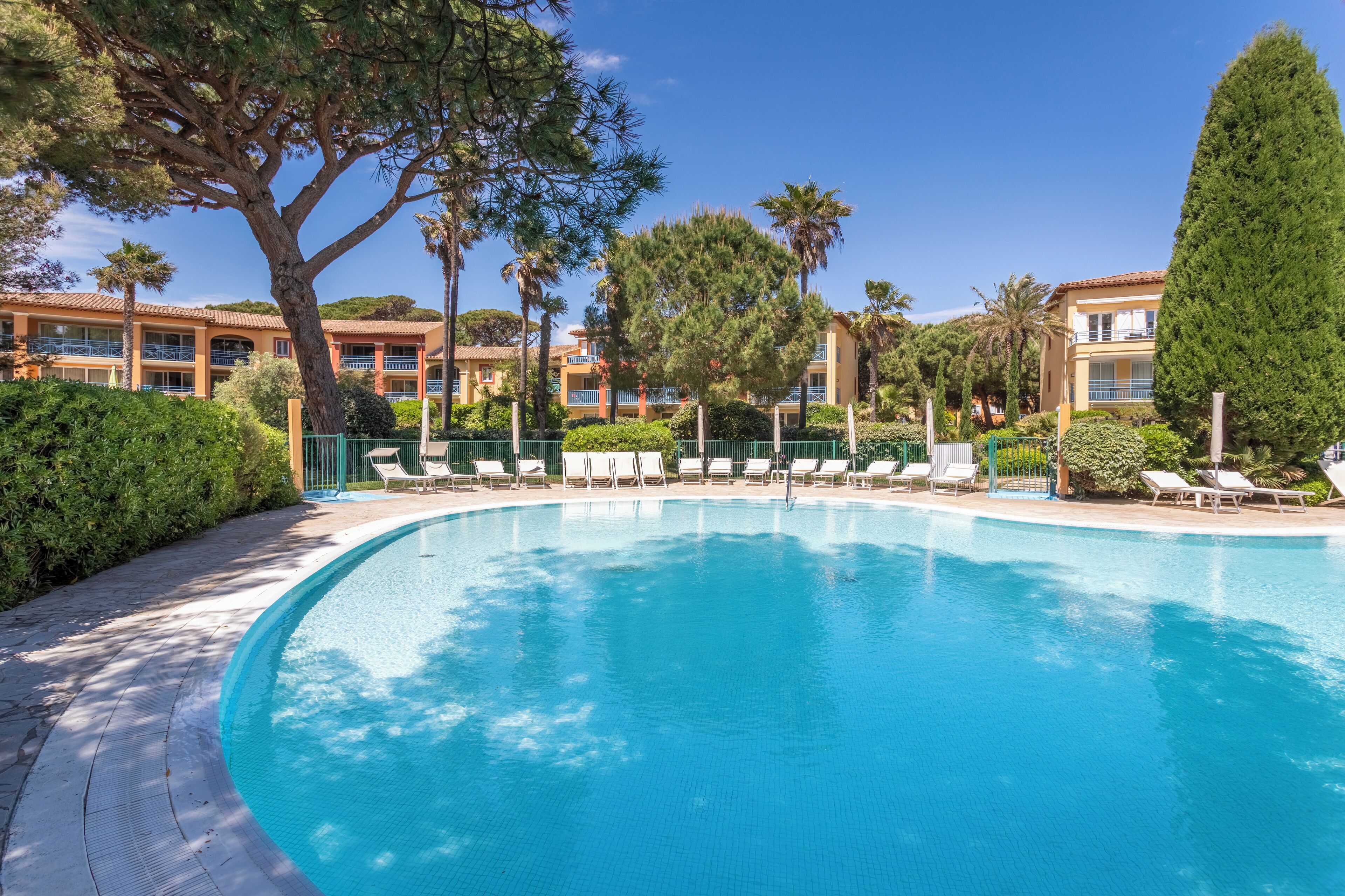 Una piscina al aire libre de temporada, sombrillas