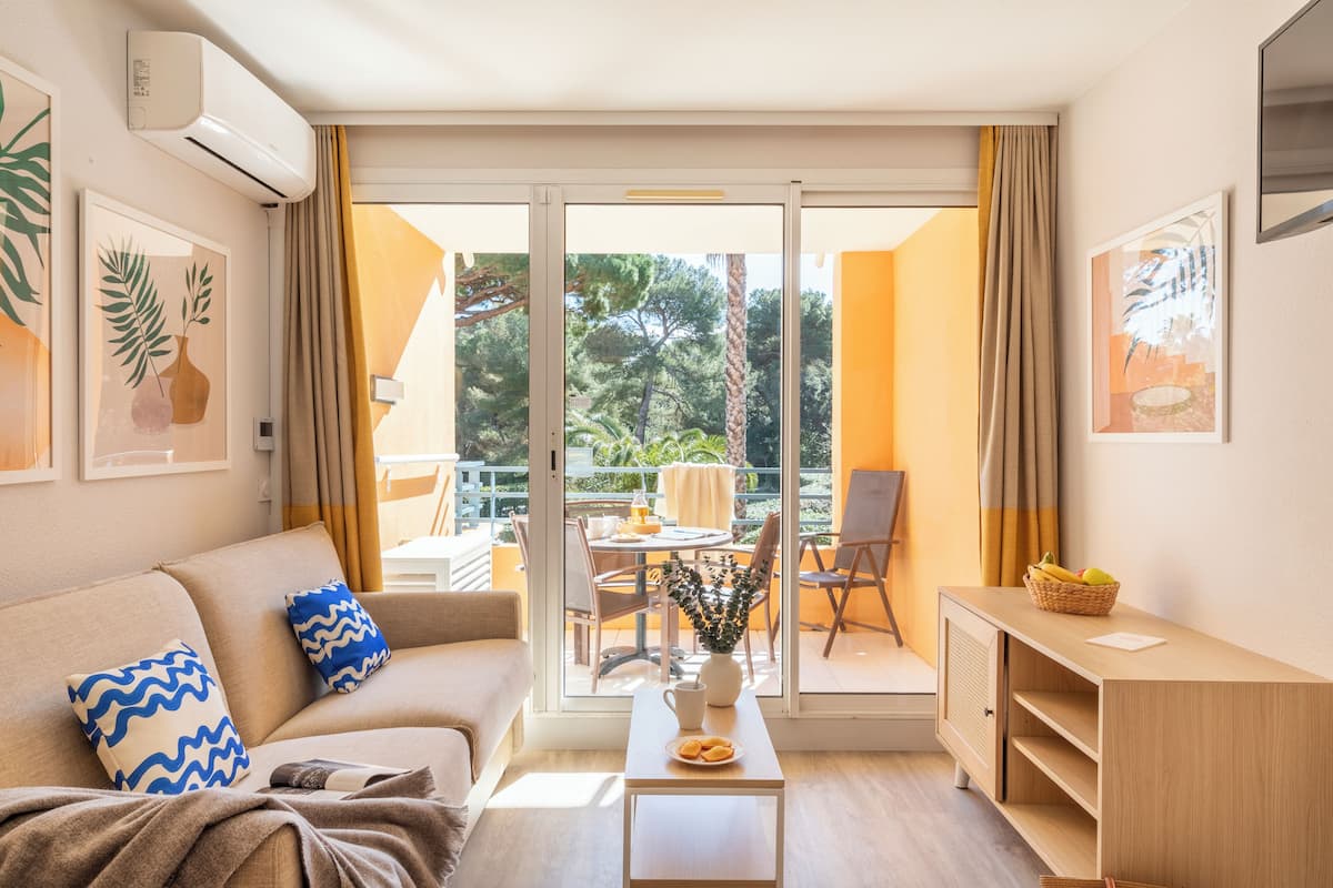 Studio 4 personnes - 1 coin nuit - Terrasse/balcon - Vue jardin - Rénové - Climatisé | Área de sala de estar | Televisión y libros