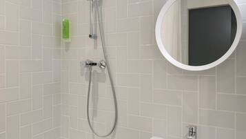 Ein modernes Badezimmer mit Dusche, Waschbecken und Spiegel.
