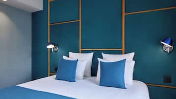 Een hotelkamer met een groot bed, twee nachtkastjes, een wandlamp en een nachtkastje.