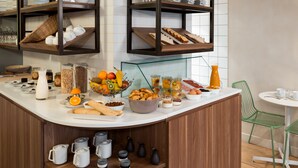 Un buffet de petit-déjeuner proposant une variété d’aliments, de boissons et d’ustensiles de cuisine.