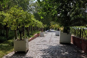 A paved pathway lined with trees and planters, leading towards a distant view. - Hôtel Sanso by HappyCulture (Ex Quality Bercy Bibliotèque) (Paris)