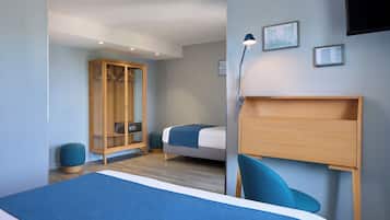 Un dormitorio moderno con una cama grande, un armario de madera, un escritorio y una silla.
