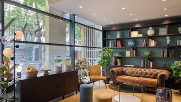 Ein modernes Interieur mit einem Ledersofa, Bücherregalen und einem Essbereich mit Obstschale.