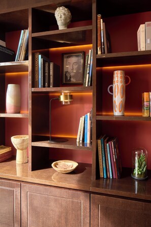 Una estantería con libros, un cuadro enmarcado y objetos decorativos.