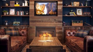 Una sala de estar acogedora con sofás de cuero, una mesa de centro de madera y una chimenea.