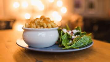 A bowl of macaroni and cheese with a side salad on a plate.