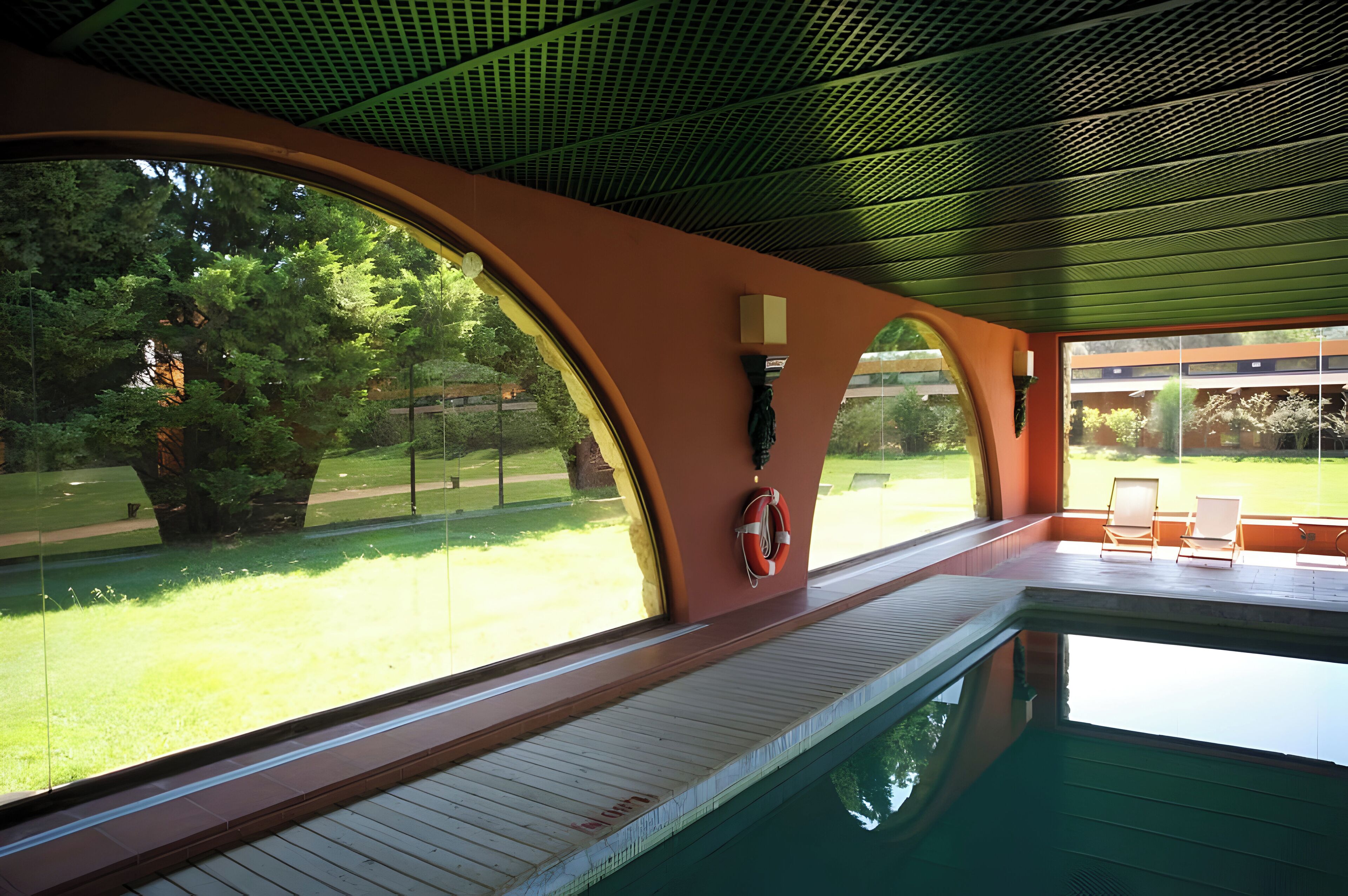 Zona de piscina con vistas a un paisaje con césped y árboles.