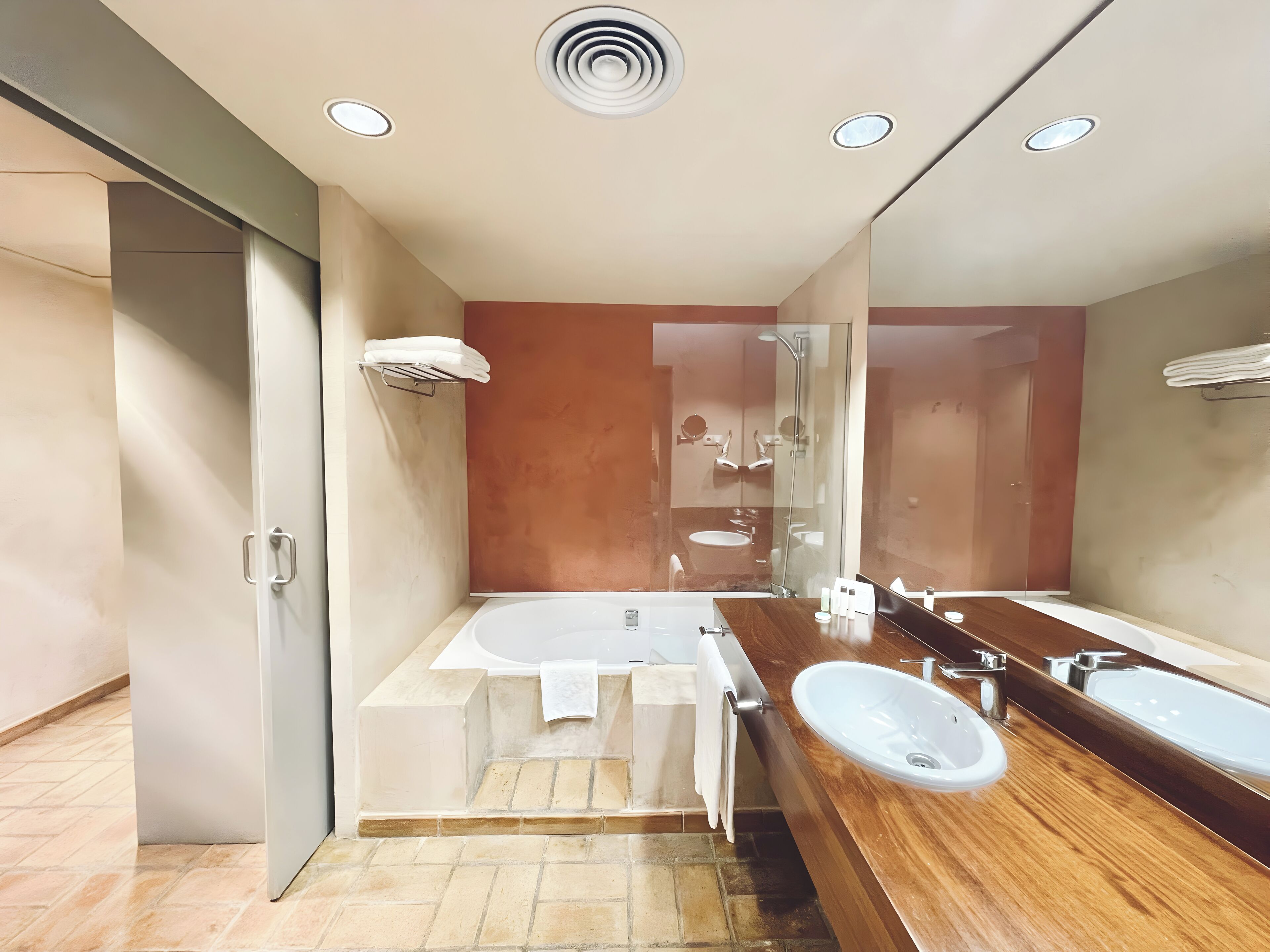 Un baño moderno con una bañera grande, dos lavamanos y una ducha con cerramiento de vidrio.