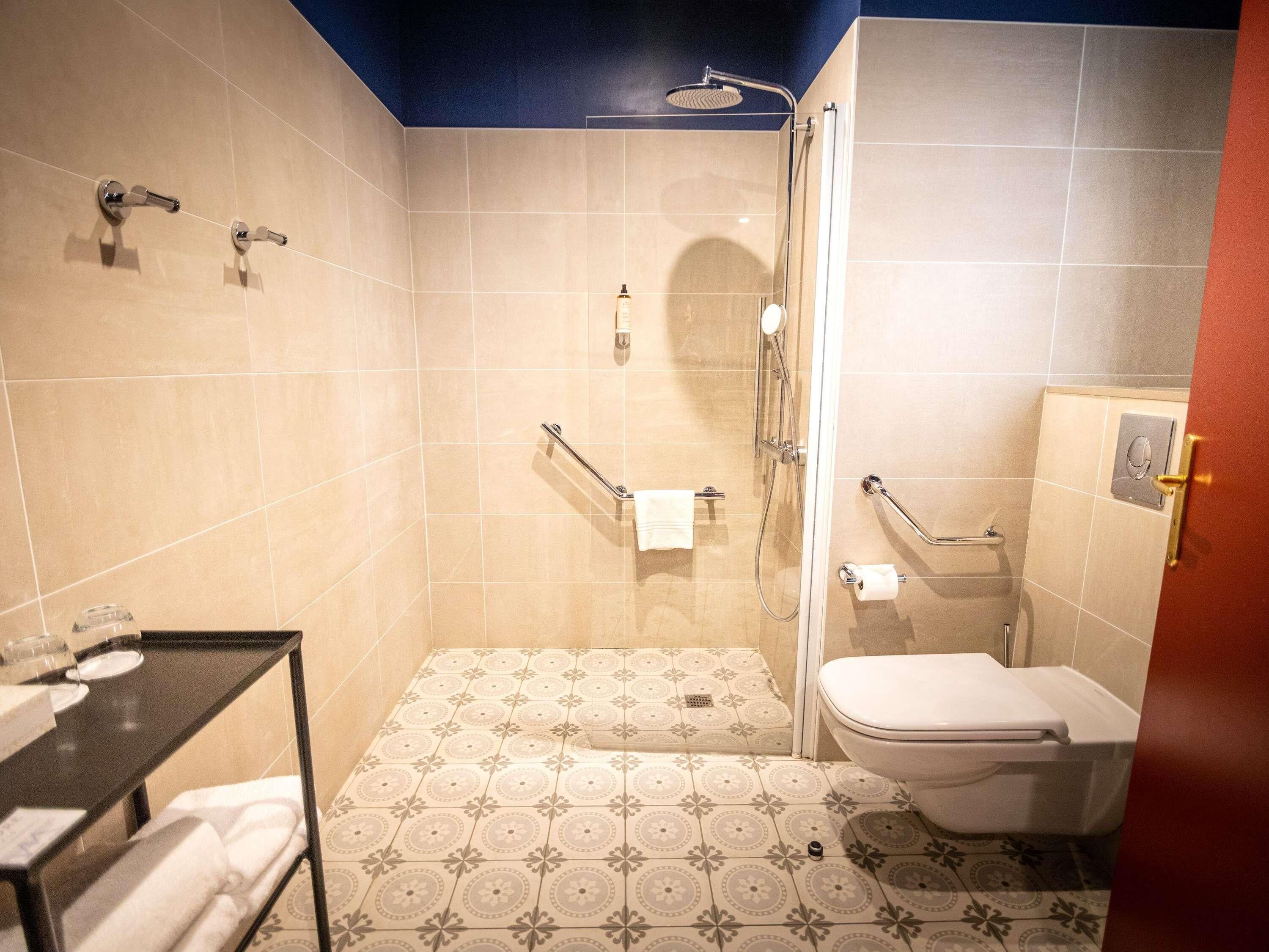 Une salle de bain avec douche, toilettes et lavabo.