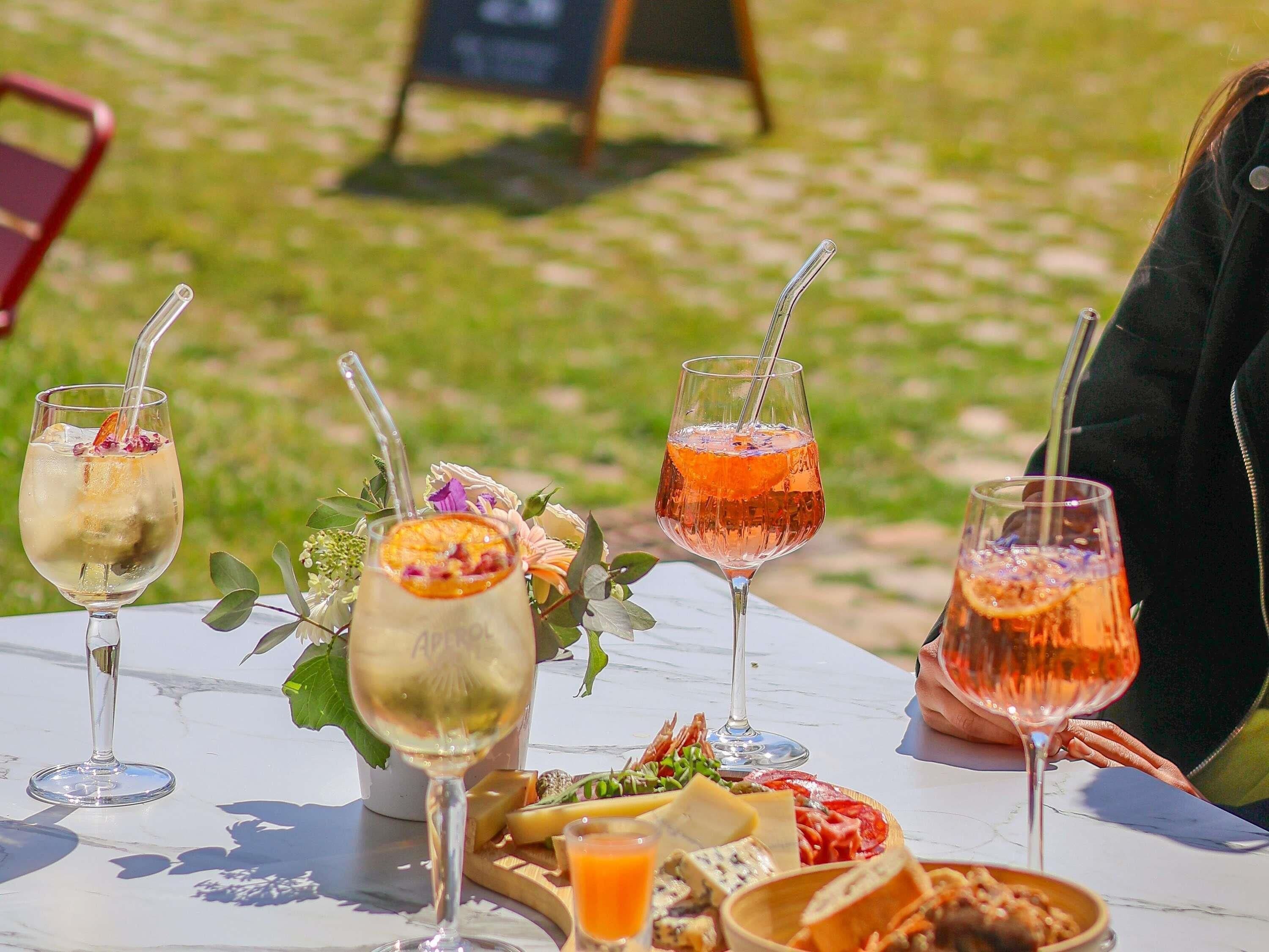A table with various drinks and a cheese board.