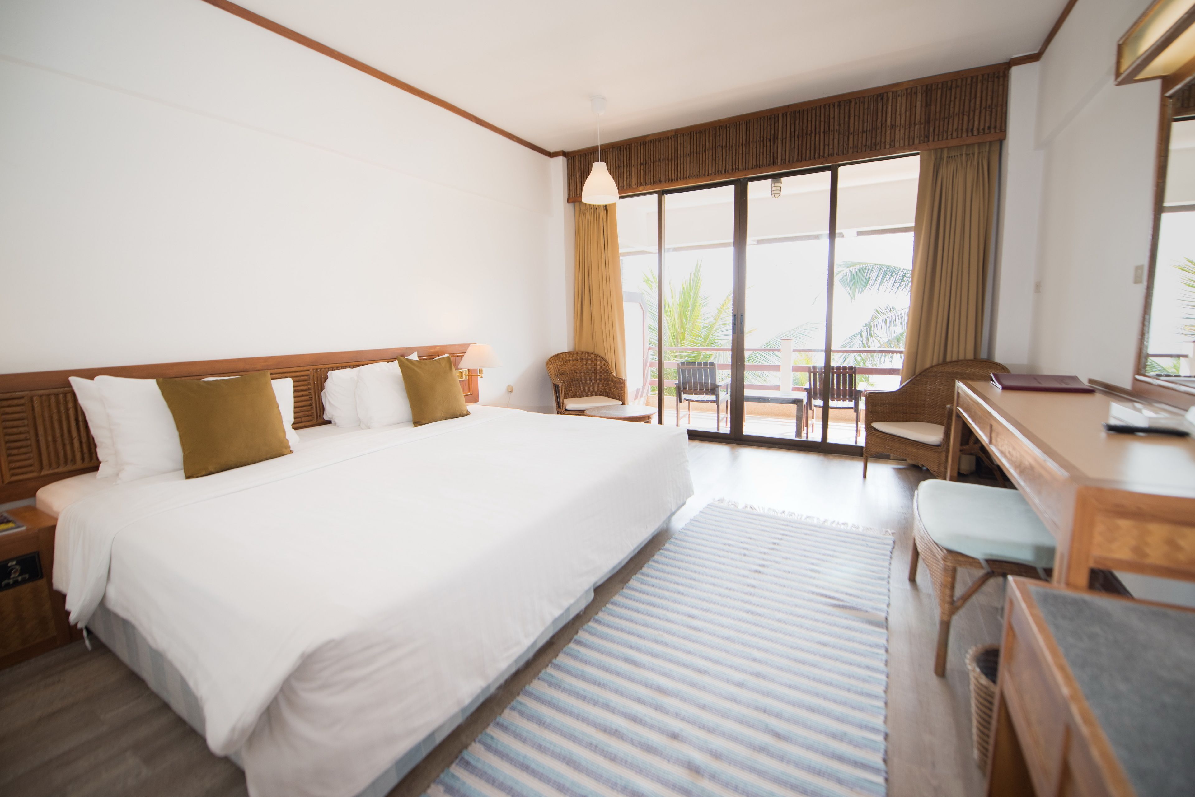 Habitación de hotel con una cama grande, un escritorio, una silla y vistas al exterior.