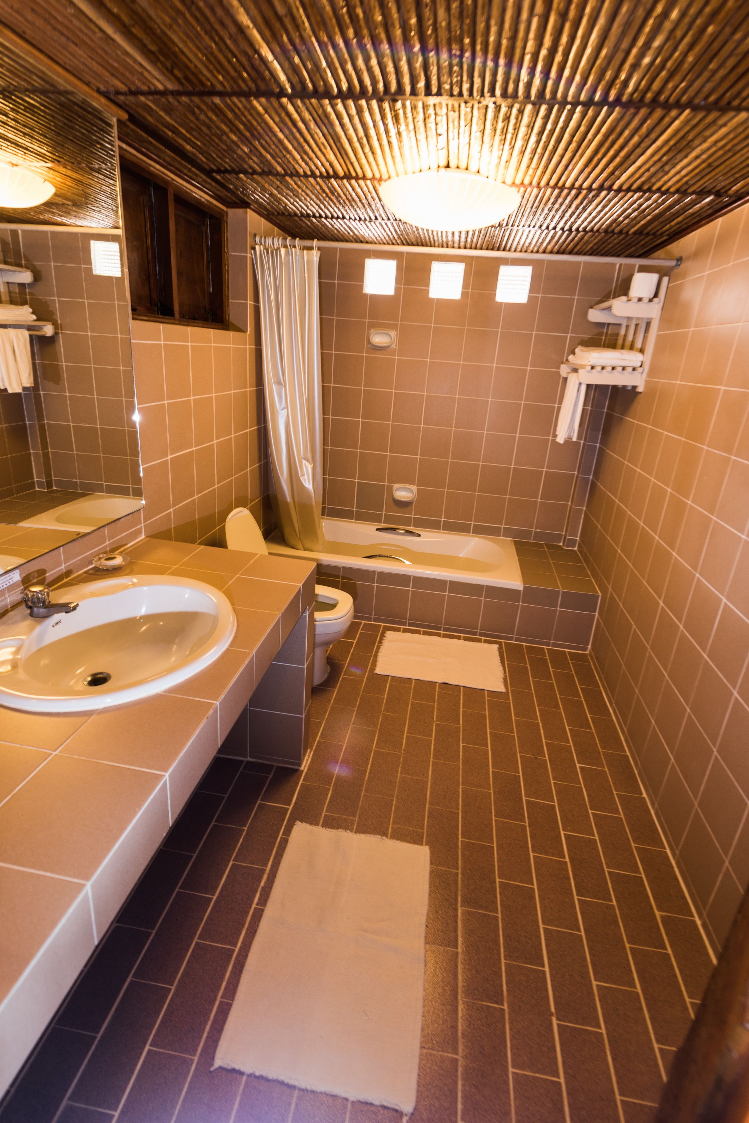 A bathroom with two sinks, a toilet, a bathtub, and a shower curtain.