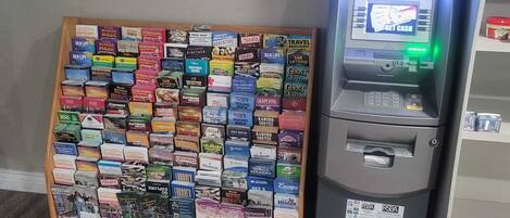 An ATM and a display of travel brochures.