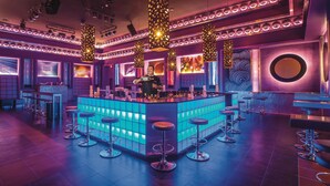 A bar area with a central island, bar stools, and ambient lighting. - Hotel Riu Cancun -  Adults Only - All Inclusive (Cancun)