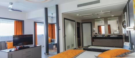 A hotel room with a bed, a TV, a desk, and a bathroom.