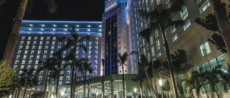 A multi-story hotel with a prominent 'RITZ' sign, palm trees, and a well-lit entrance.