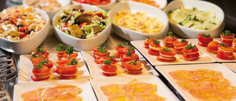 Een buffet met diverse gerechten, waaronder pasta, salades en voorgerechten.