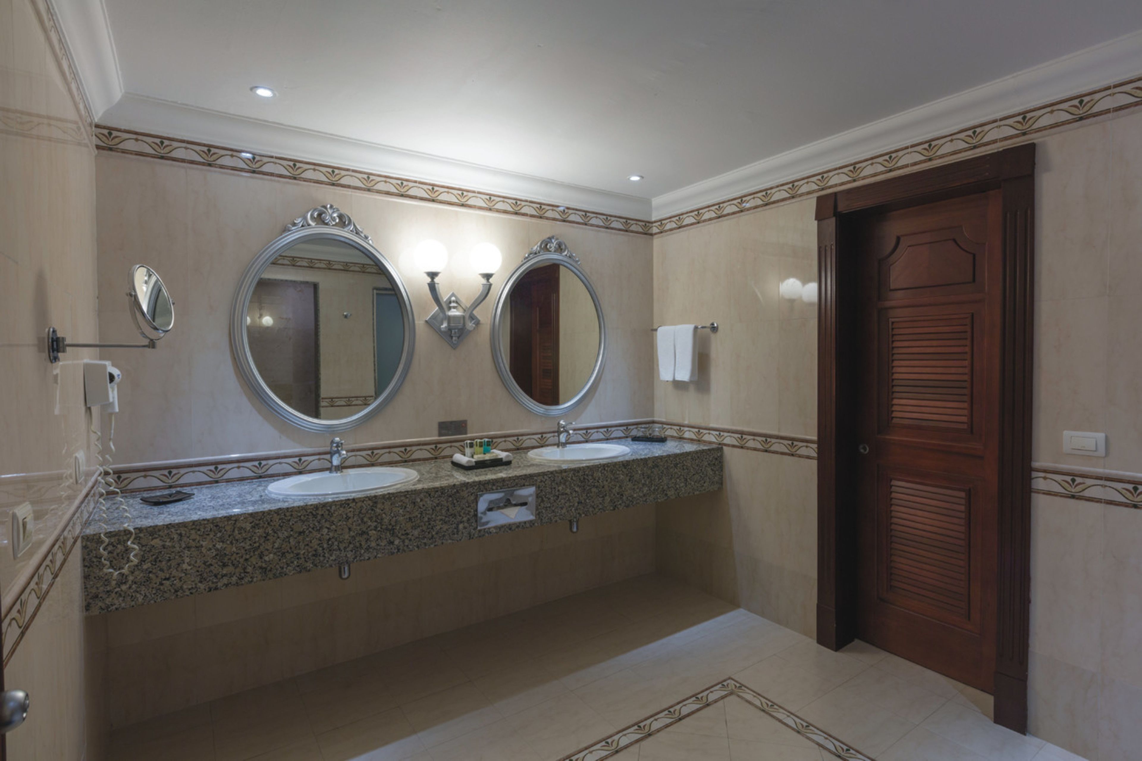 A bathroom with two sinks, a mirror, and a towel rack.