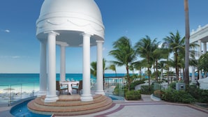A white gazebo with columns, overlooking a beach with palm trees and a clear blue sky. - Hotel Riu Palace Las Americas - Adults Only- All Inclusive (Cancun)