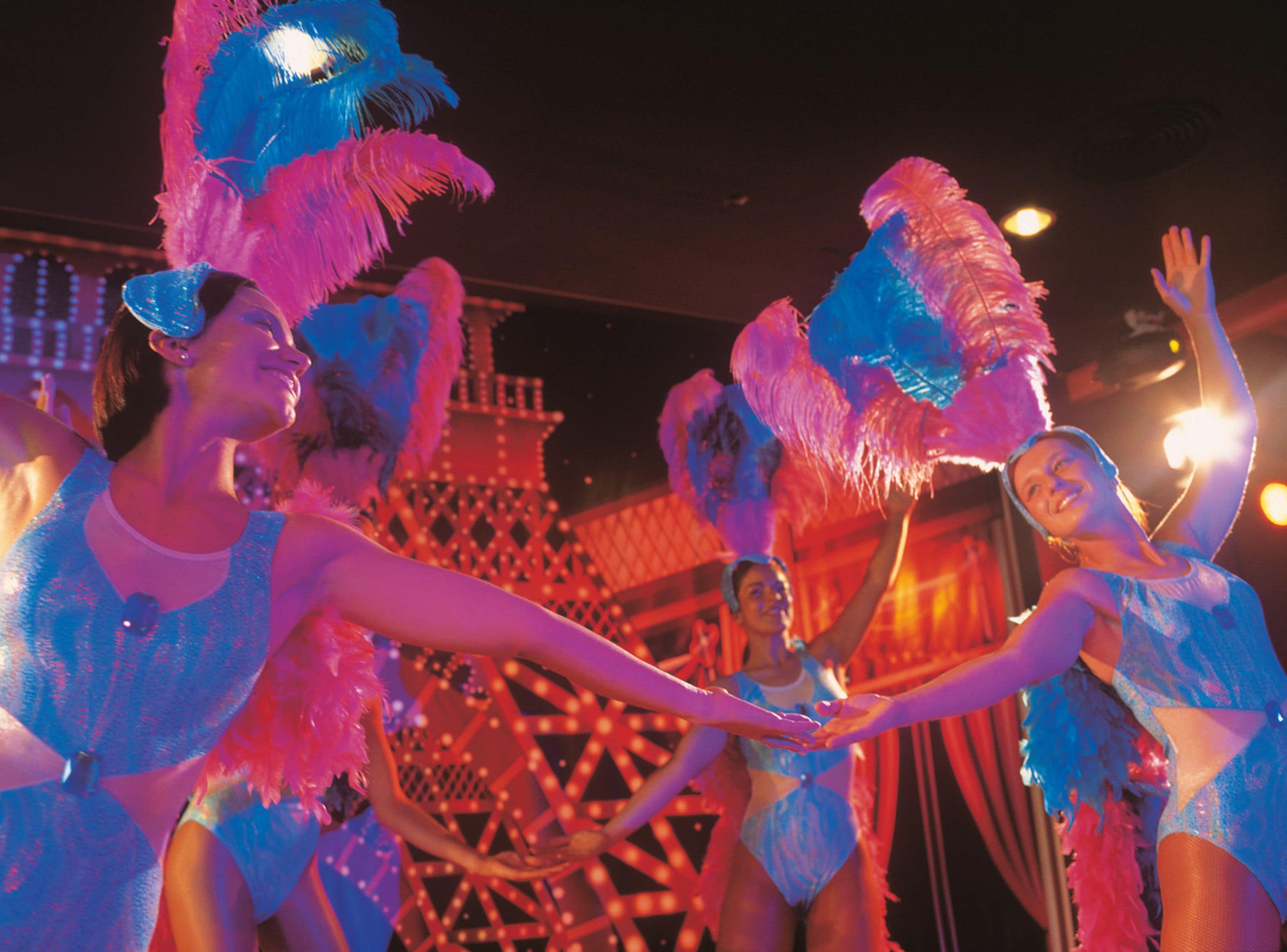 A group of people in a festive setting with a large, illuminated structure in the background.
