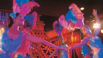A group of people in a festive setting with a large, illuminated structure in the background.