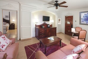 A living room with a sofa, a coffee table, a TV, and a wooden cabinet.