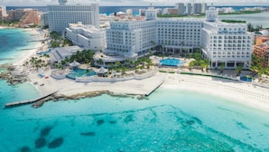A large resort with multiple buildings, a central pool, and a beach area. - Hotel Riu Palace Las Americas - Adults Only- All Inclusive (Cancun)