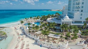 A resort with a beach, a pool, and a large building with a dome. - Hotel Riu Palace Las Americas - Adults Only- All Inclusive (Cancun)