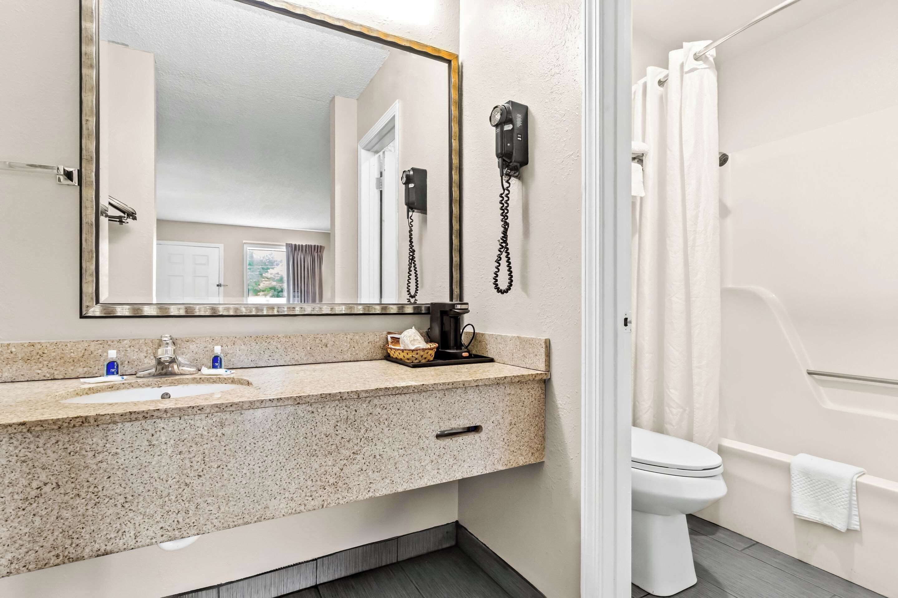 A bathroom with a sink, mirror, and toilet.
