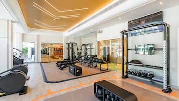Un gimnasio moderno con cintas de correr, máquinas de pesas y pesas libres.