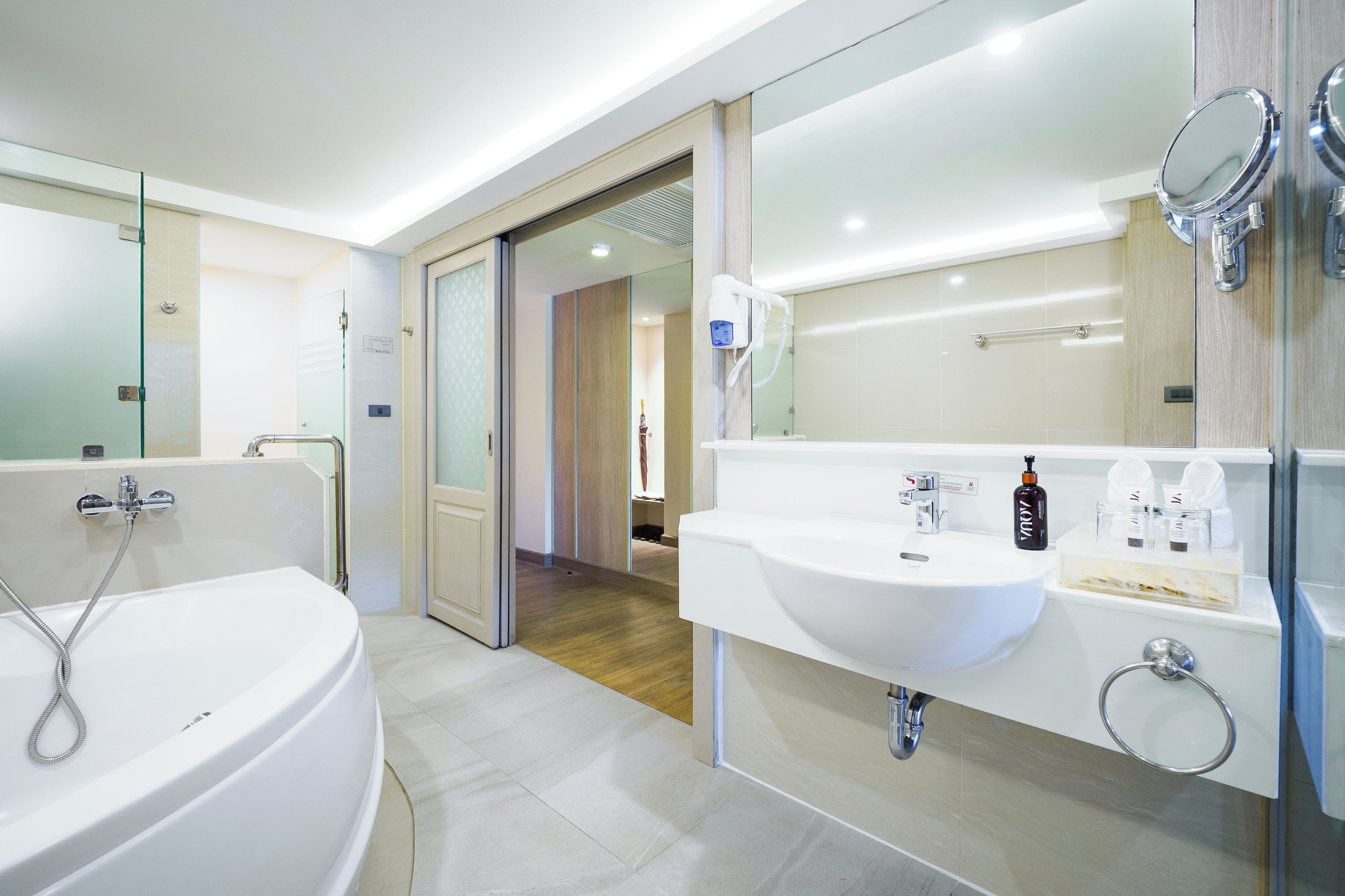 A modern bathroom with a bathtub, a sink, and a mirror.