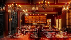 A restaurant with multiple dining tables set for guests, a bar area with shelves of bottles, and ornate chandeliers. - Katathani Phuket Beach Resort (Karon)
