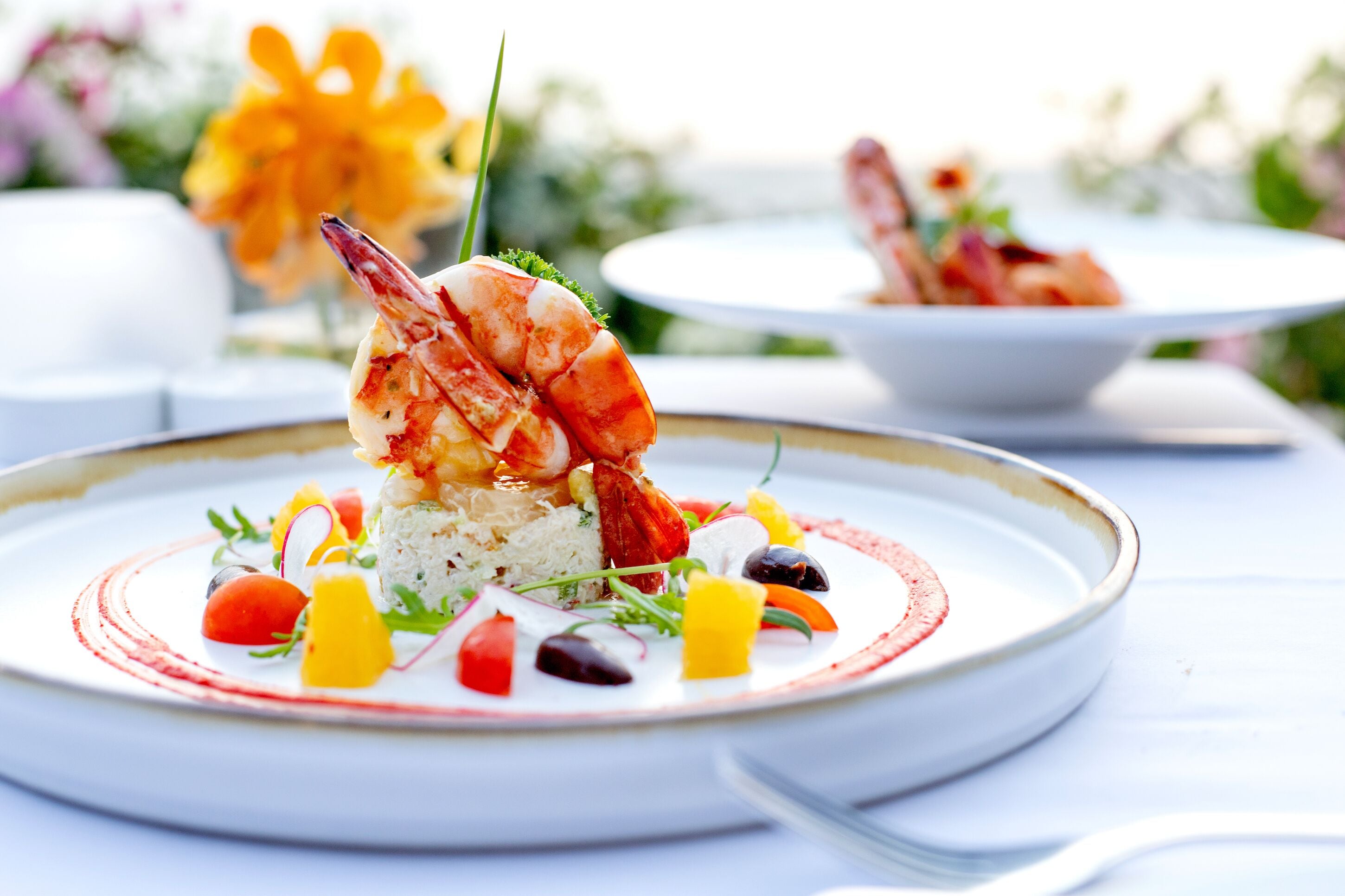 Un plato de mariscos con arroz y verduras sobre un plato blanco.
