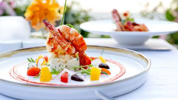 Un plato de mariscos con arroz y verduras sobre un plato blanco.