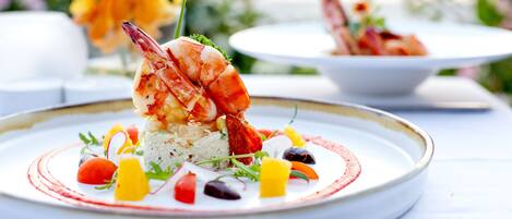 Un plato de mariscos con arroz y verduras sobre un plato blanco.