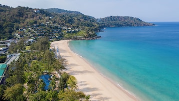A coastal resort with beachfront villas, a swimming pool, and a view of the ocean.