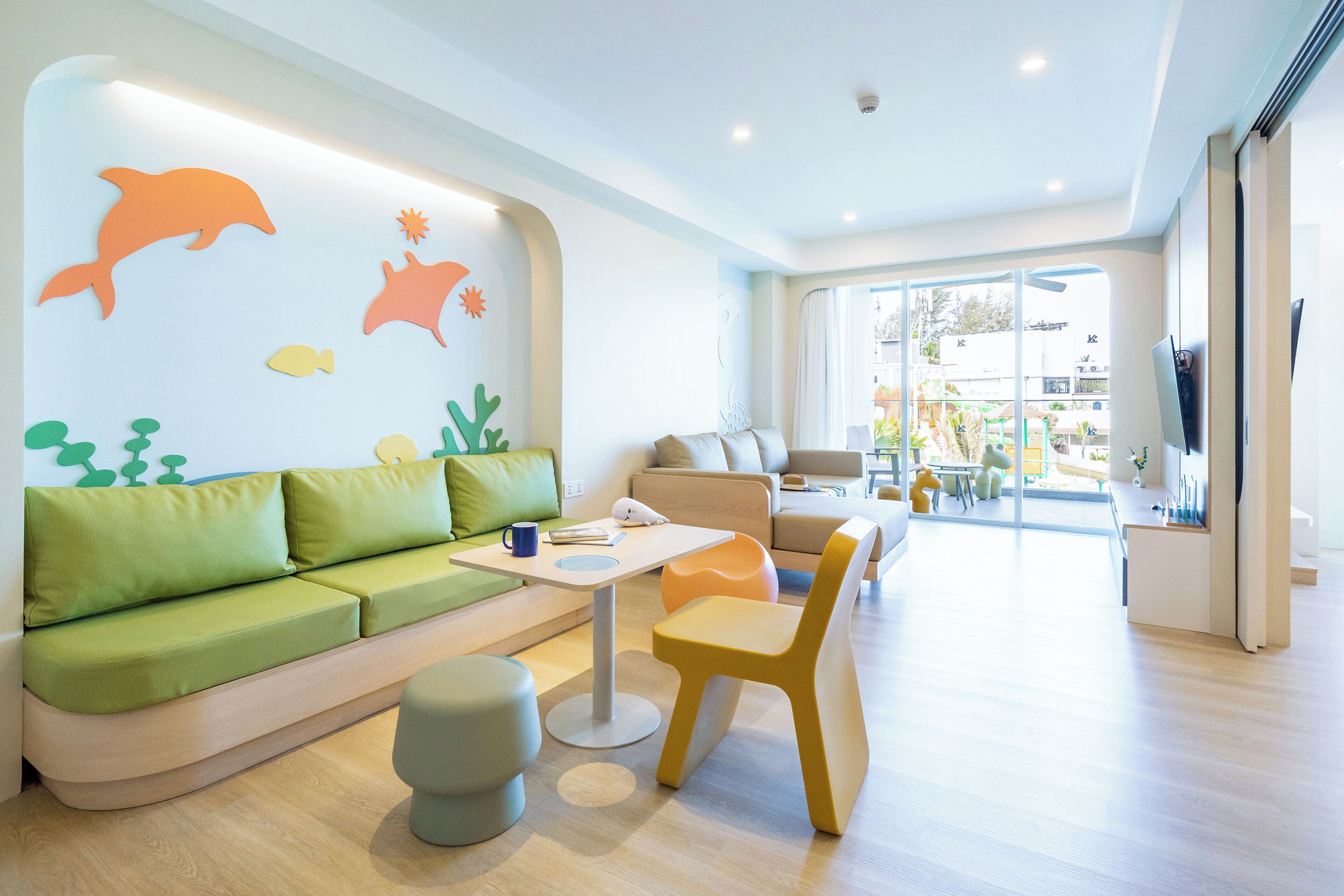 Ein modernes Interieur mit einem grünen Sofa, einem gelben Sessel und einem weißen Tisch.