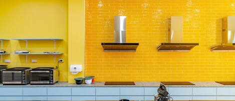 A kitchen with yellow walls, two built-in toasters, a sink, and a range hood.