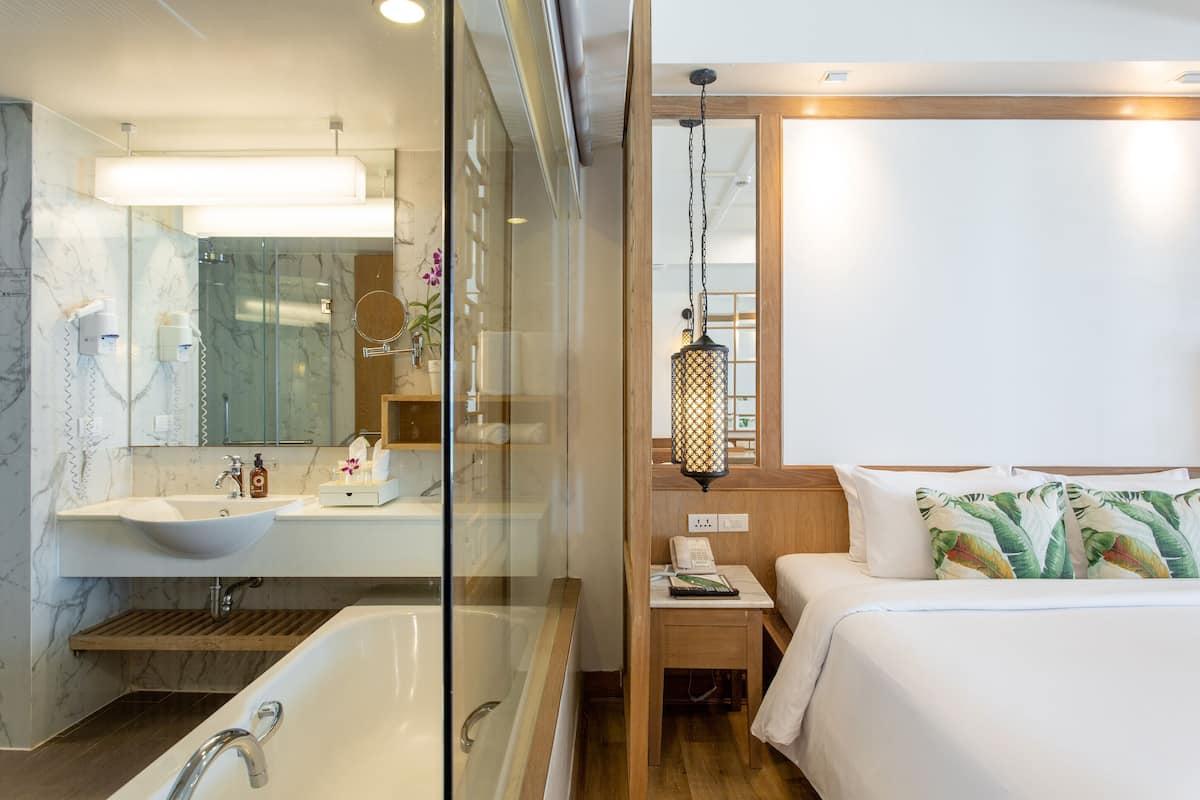 Ein modernes Badezimmer mit einer großzügigen Badewanne, einer Duschkabine und einem Waschtisch mit Spüle und Spiegel.