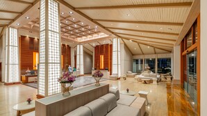 A spacious lobby with a high ceiling, wooden beams, and a central seating area with sofas and a coffee table. - Katathani Phuket Beach Resort (Karon)
