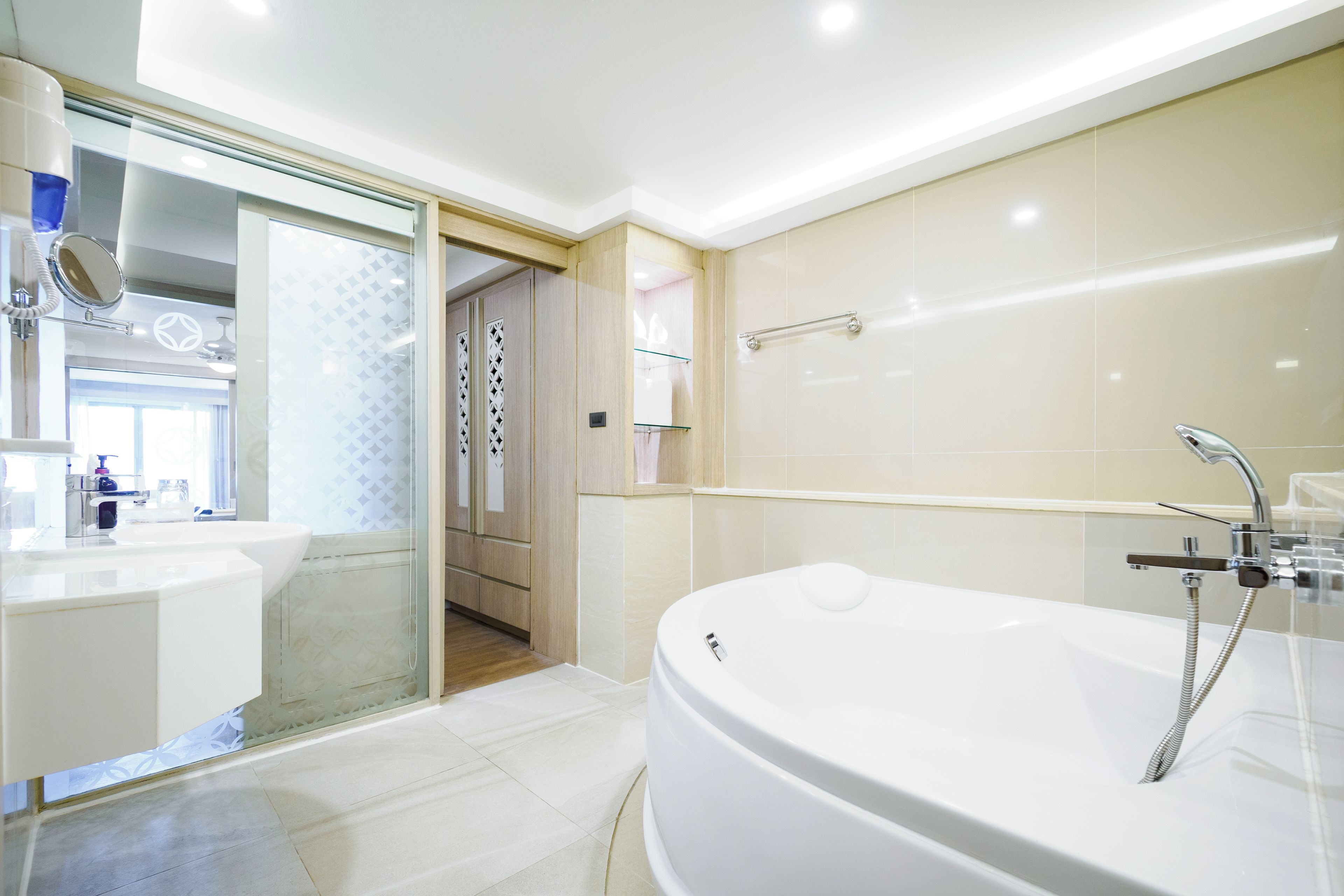 A modern bathroom with a freestanding bathtub, a glass shower enclosure, and a vanity with a mirror.