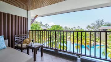 A balcony with a view of a swimming pool and palm trees.