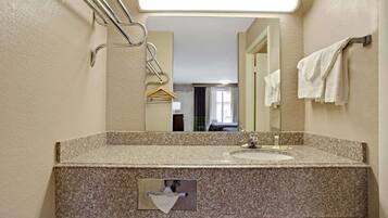 Un bagno con un piano in granito, un lavandino, un porta asciugamani e uno specchio.