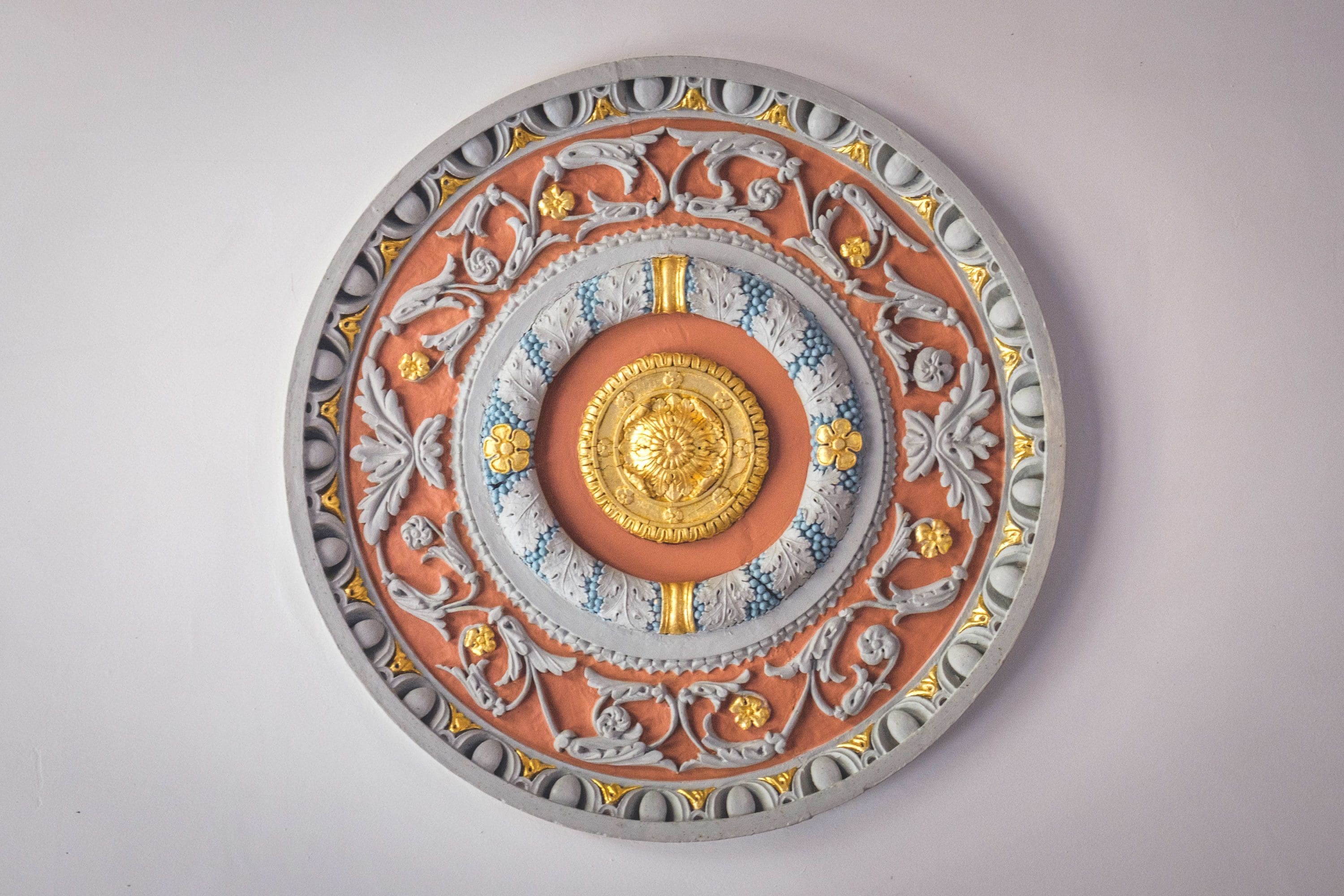 Um prato decorativo circular com padrões elaborados e um emblema central.